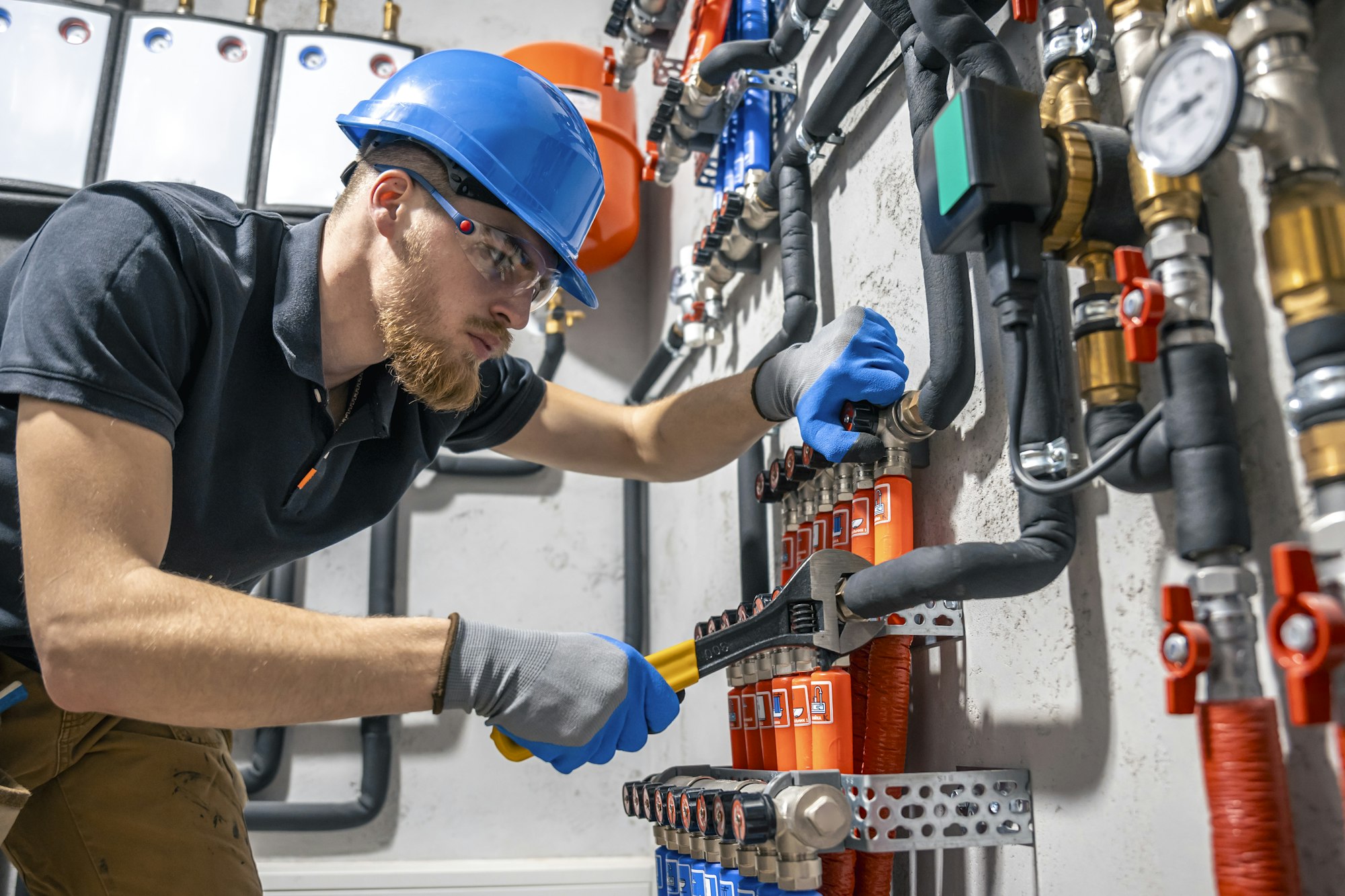 The technician checking the heating system in the boiler room.